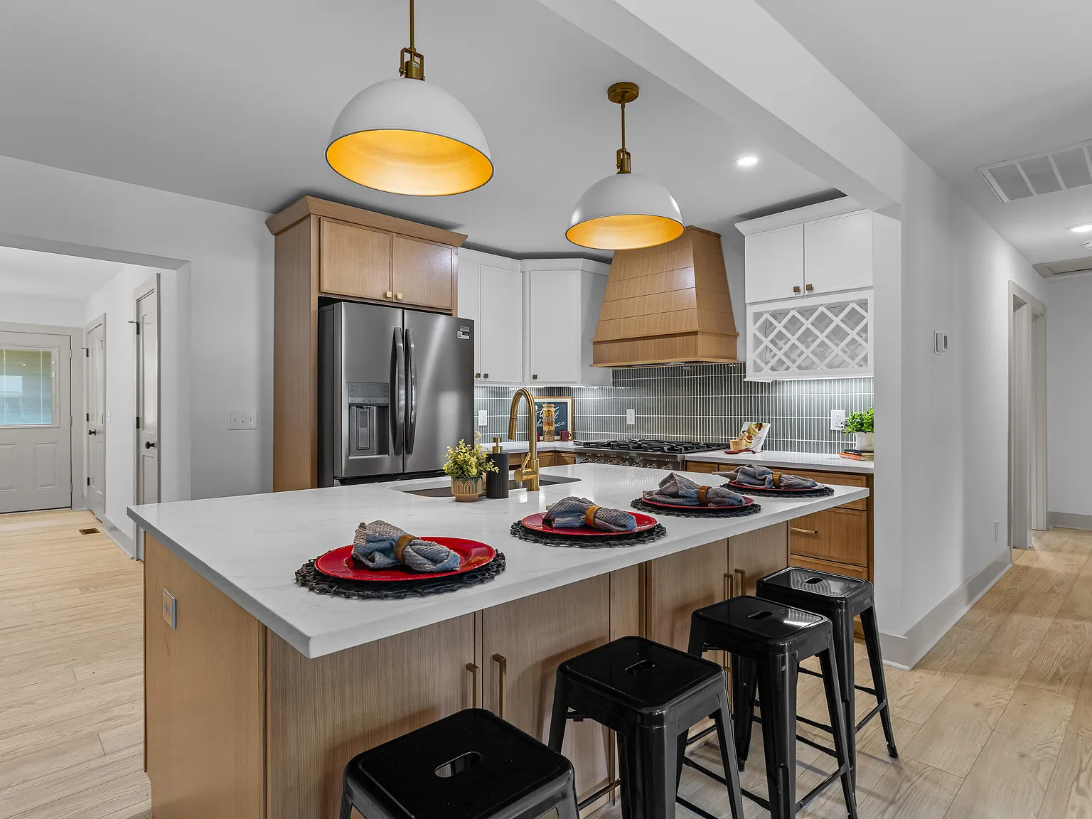 Kitchen with marble waterfall island and twin white dome pendants