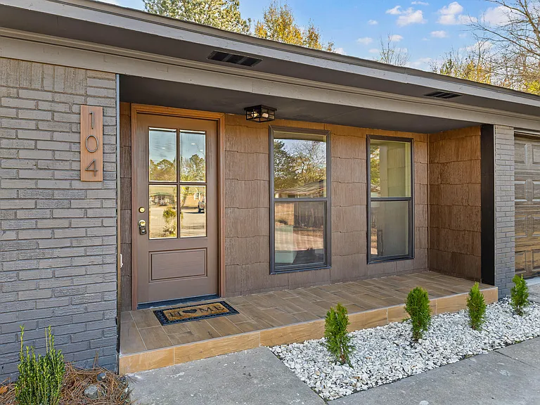 Modern brick entry detail with wood door and black house numerals